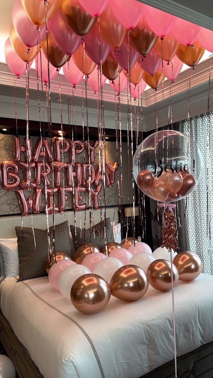 Hotel suite styled with rose gold and blush balloons and a personalised bubble balloon